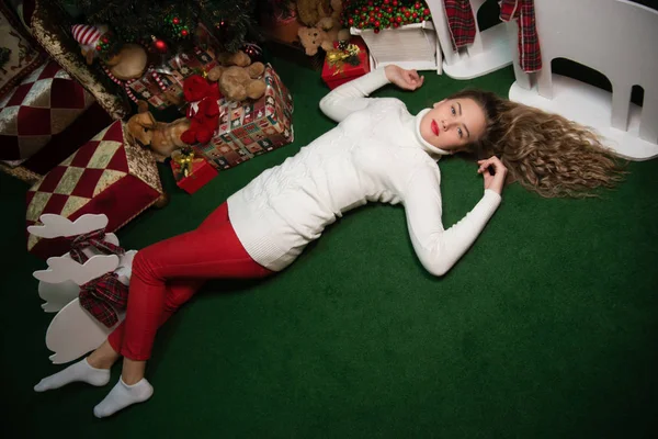 Girls lie next to the Christmas tree with gifts — Stock Photo, Image