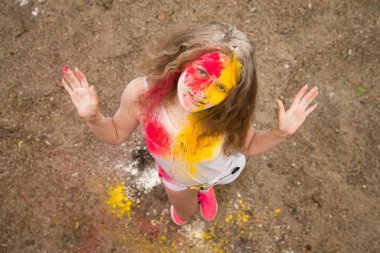 gür saçları parlak bir kız gülümsüyor, saç, yüz ve eller Holi renklerde 