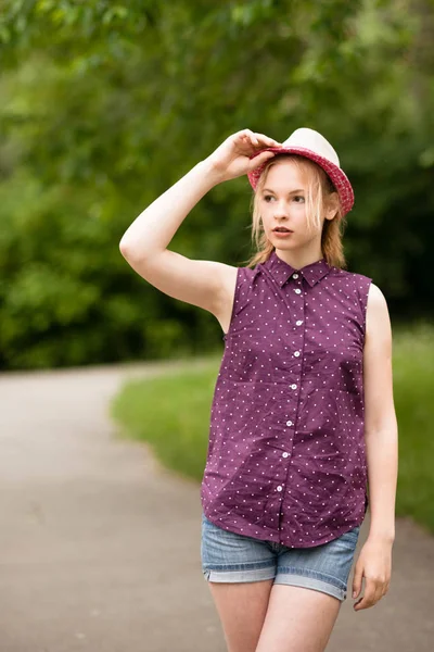 Hermosa joven rubia en sombrero y camisa en el fondo de la naturaleza — Foto de Stock