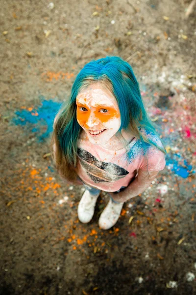 Holi olan saç, yüz ve ellerinde boya parlak sarışın kız 