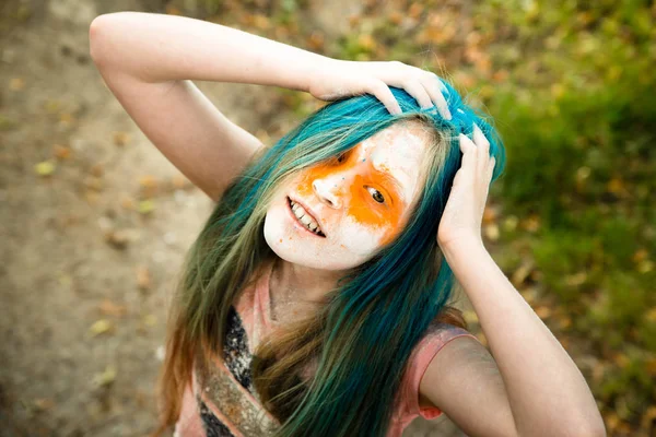 Menina loira brilhante cujo cabelo, rosto e mãos em pintura Holi — Fotografia de Stock