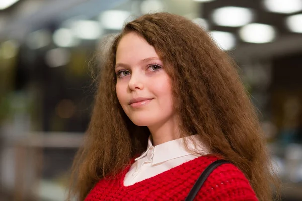 beautiful girl with lush hair standing indoors