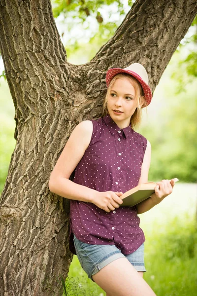 Genç sarışın kız güzel şapka ve doğa arka plan forması 