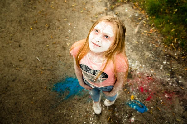 Una chica brillante sonríe, ella está en los colores de Holi Imágenes De Stock Sin Royalties Gratis