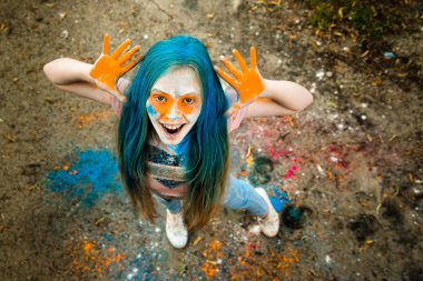 Holi olan saç, yüz ve ellerinde boya parlak sarışın kız 