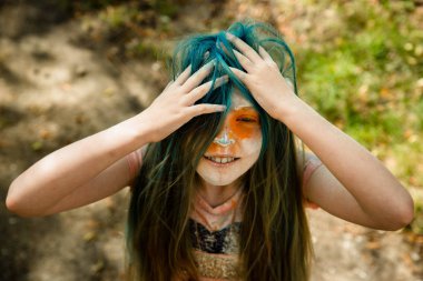 Holi olan saç, yüz ve ellerinde boya parlak sarışın kız 