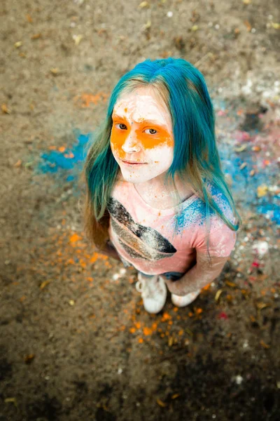 Holi olan saç, yüz ve ellerinde boya parlak sarışın kız 