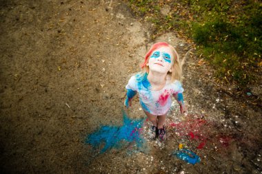 parlak kız gülümsüyor, onun yüzünü ve ellerini renkli Holi 