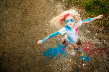 parlak kız gülümsüyor, onun yüzünü ve ellerini renkli Holi 