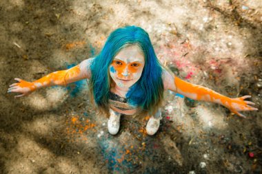 Holi olan saç, yüz ve ellerinde boya parlak sarışın kız 