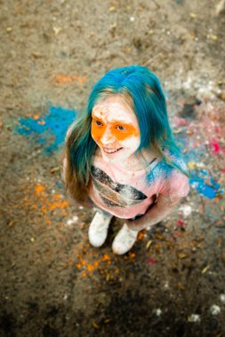 Holi olan saç, yüz ve ellerinde boya parlak sarışın kız 