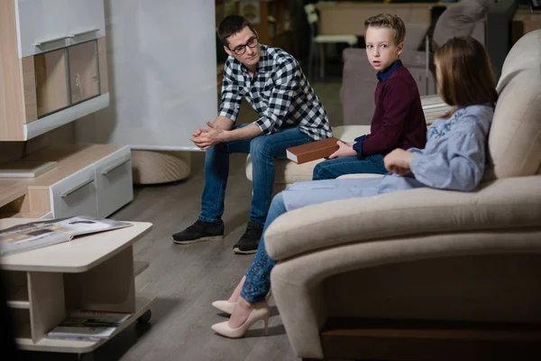 otururken, bir çocuk oturan bir genç adam ve oturan kız ve onlar odaya konuşmak