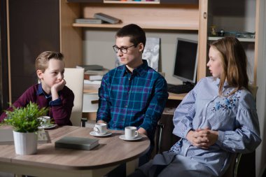 Genç bir adam, bir erkek ve kız masada oturan ve söz