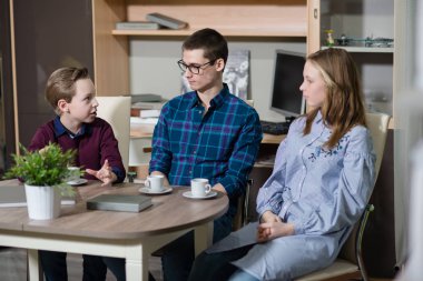 Genç bir adam, bir erkek ve kız masada oturan ve söz