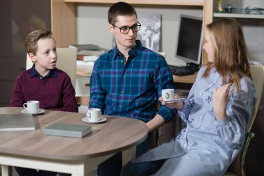 Genç bir adam, bir erkek ve kız masada oturan ve söz