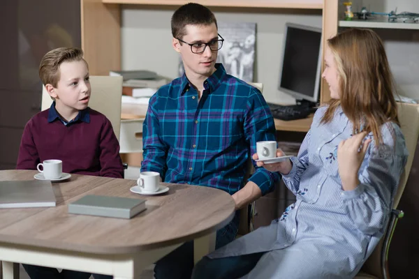 Genç bir adam, bir erkek ve kız masada oturan ve söz