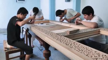 Ahşap ürünlerdeki kalıpların oymacıları. Dört genç zanaatkar doğuya özgü bir model yaratmak için çalışıyorlar..