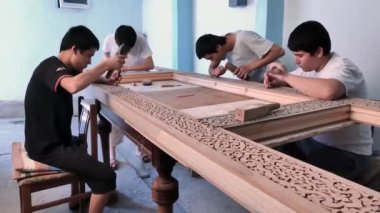 Ahşap ürünlerdeki kalıpların oymacıları. Dört genç zanaatkar doğuya özgü bir model yaratmak için çalışıyorlar..