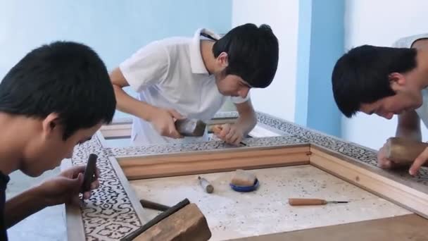 若い主人は木彫に従事している 古楽器との共演 木の民族模様の制作などを行う — ストック動画