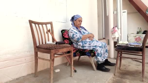 Old Asian Woman Headscarf Sits Chair She Sits Comfortably Courtyard — Stock Video