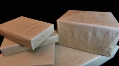 Birkaç farklı boyutta kutu düz kağıda sarılır. Hediye kutuları kraft kağıdıyla dolu. Sağa git..