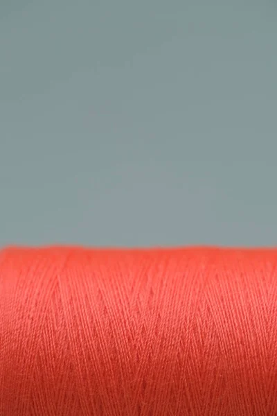 糸の固体サンゴスプール クローズアップ 灰色の背景に隔離された 色のついた糸 カラフルなボビン糸 — ストック写真