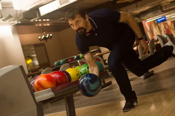 Erkek oyuncu bowling kulüpte bovling oynuyor.