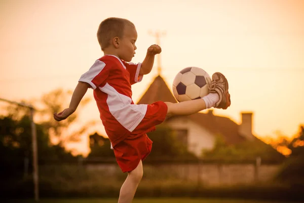 ほとんどの 歳男の子はサッカー 屋外運動場でサッカー ボールを撮影 ストックフォト