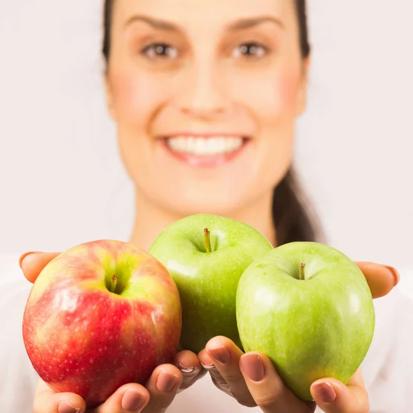 三成熟的苹果在女性手 美丽的笑脸在白色背景 健康饮食理念 — 图库照片