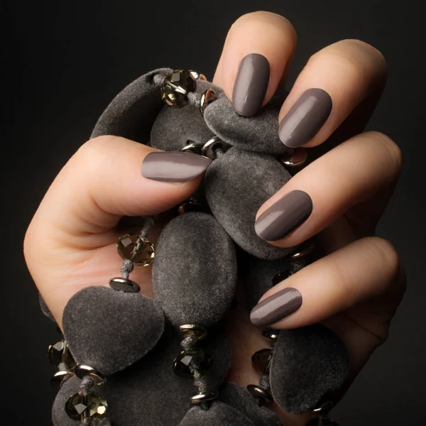 Main Féminine Avec Des Ongles Gris Foncé Brillant Tient Bijoux — Photo