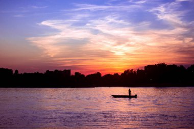 Sırbistan'daki Tuna Nehri üzerinde bulutlu gökyüzü üzerinde renkli gün batımı ile güzel manzara.