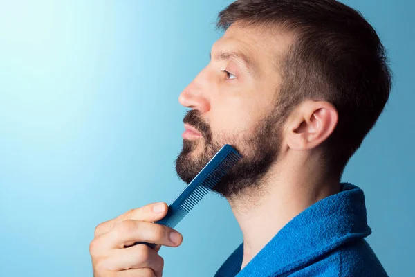Homem Meia Idade Está Penteando Sua Barba Fundo Azul Conceito — Fotografia de Stock