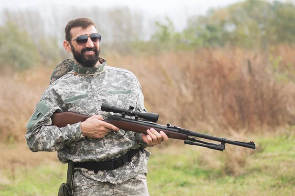 Askeri Üniformalı Gülümseyen Asker Dışarıda Bir Pompalı Tüfek Hava Tüfeği — Stok fotoğraf