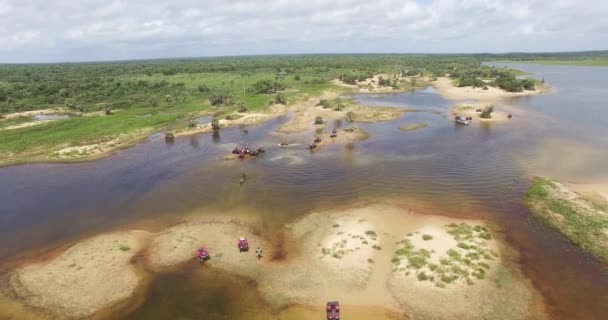 Certains quads VTT traversant l'eau, dans des dunes de sable avec beaucoup d'eau, tournent avec un drone, vue aérienne. L'endroit est célèbre pour le tourisme, et ont beaucoup de couleurs, dans lencois maranhenses, Brésil 