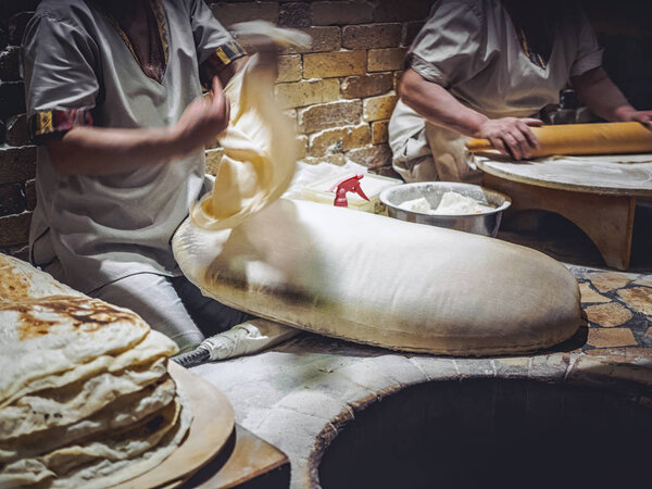 cropped shot of men preparing lavash on market at Armenia