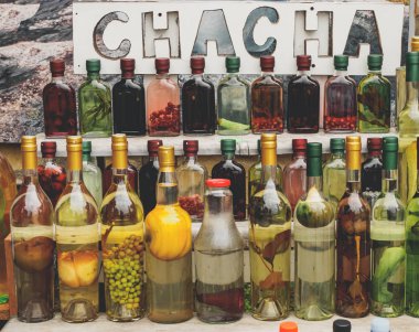 geleneksel Gürcü alkol içki chacha ile farklı meyveler ve otlar piyasa satış şişelerde
