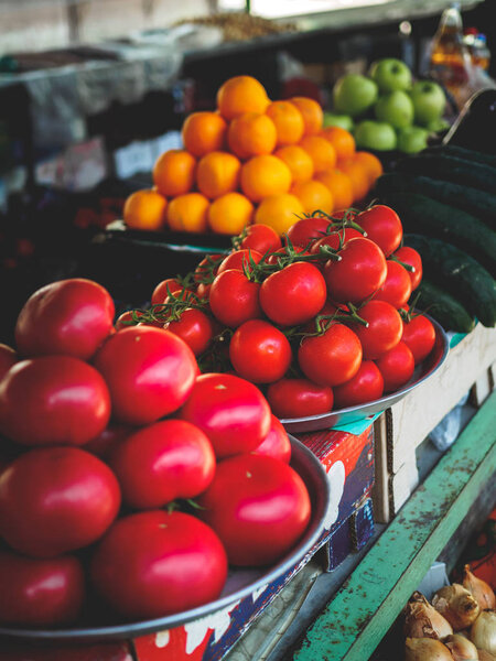 red and yellow tomatoes, cucumbers and apples at georgian market stall