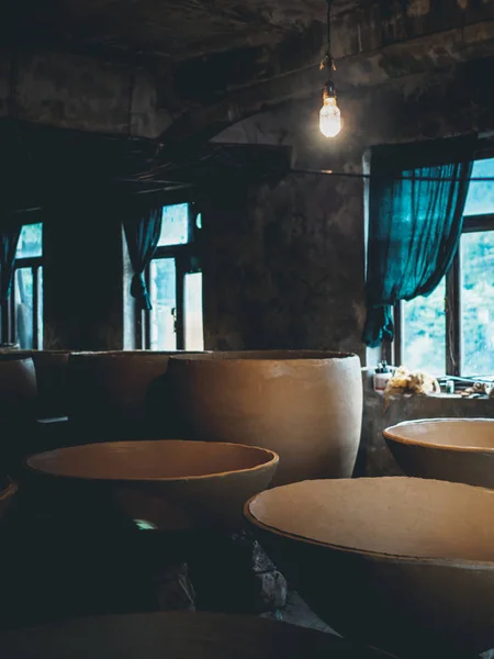 Grandes citernes d'argile pour la production de vin et lampe en atelier en géorgie — Photo de stock