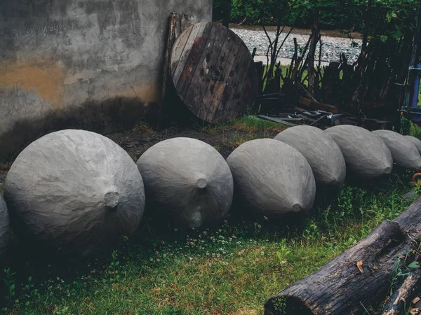 Grandes cisternas de arcilla para la producción de vino sobre hierba en el patio en Georgia - foto de stock