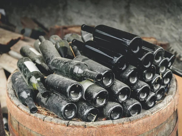 Primer plano de botellas de vino usadas sucias vacías en pila en barril de madera en Georgia - foto de stock