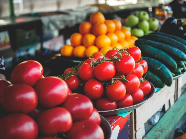 Red and yellow tomatoes, cucumbers and apples at georgian market — Stock Photo