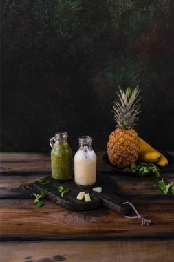 Rustik ahşap tahta üzerinde tropikal meyve ile lezzetli detoks smoothies