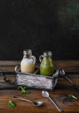 Ahşap arka plan üzerinde organik yeşil ve beyaz smoothies