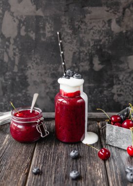 Delicious detox smoothie in bottle and jar on rustic wooden board clipart