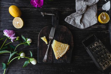 lezzetli limon pasta ve çiçekler parça ahşap masa üzerinde yukarıdan
