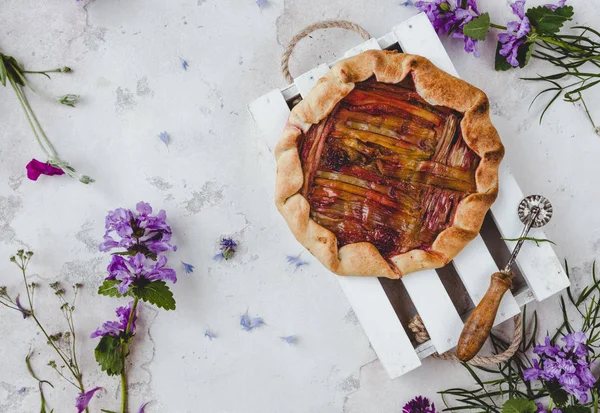 Vedere Sus Plăcintei Delicioase Rubarbă Flori Împrăștiate Masă — Fotografie, imagine de stoc