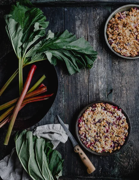 Vista Superior Pasteles Sabrosos Cocidos Con Bayas Ruibarbo Mesa Madera — Foto de Stock