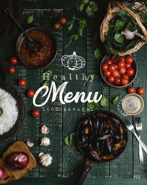 Top view of cooked mussels with shells served in pan with tomatoes, herbs and wine on wooden table, healthy menu lettering