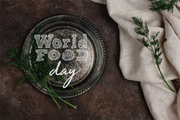 在黑暗的表面上 有漏斗和桌布的复古盘子的顶视图 世界食物日的刻字 — 图库照片