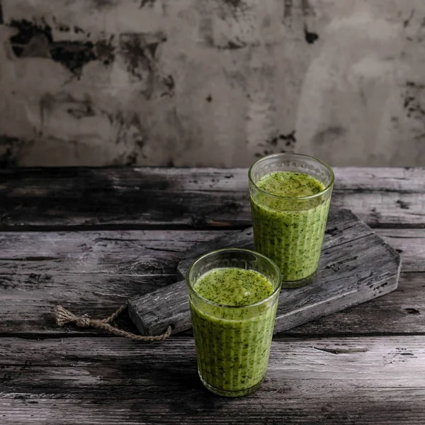 Smoothie verde orgânico em óculos na mesa de madeira — Fotografia de Stock